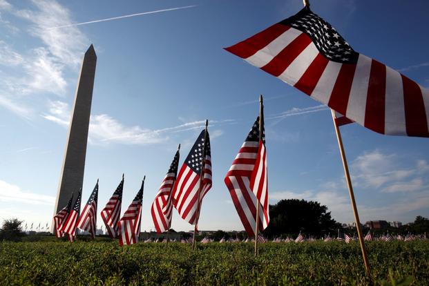 Description: 5,000 small U.S. flags representing suicides of active and veteran members of the military line the National Mall, Wednesday, Oct. 3, 2018, in an action by the Iraq and Afghanistan Veterans of America (IAVA), in Washington. (AP Photo/Jacquelyn Martin)